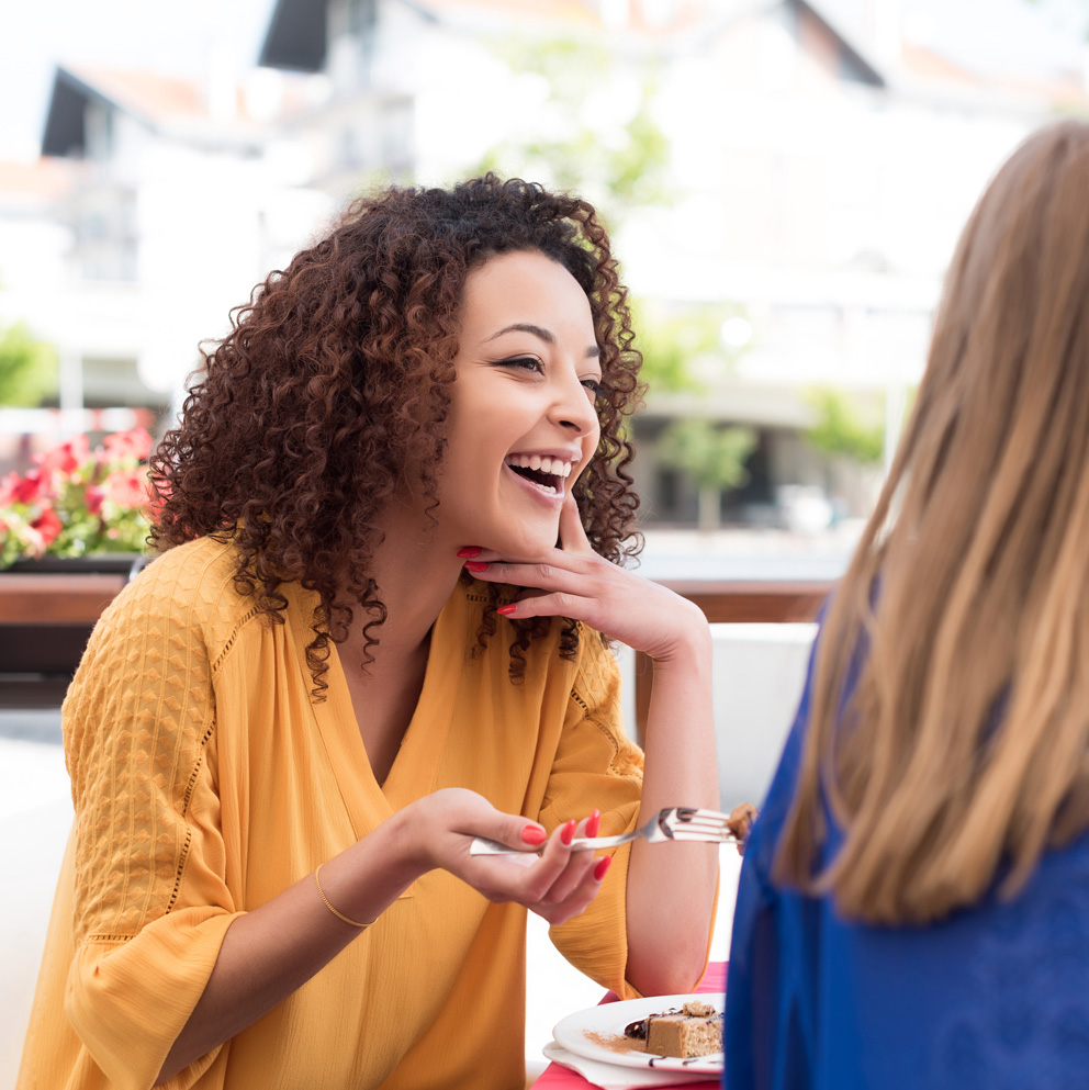 Photo of a young woman with clear, healthy skin having lunch with a friend