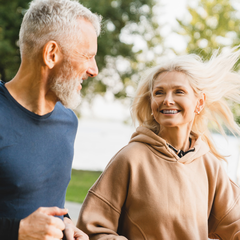 Photo of a healthy older couple exercising together in the park